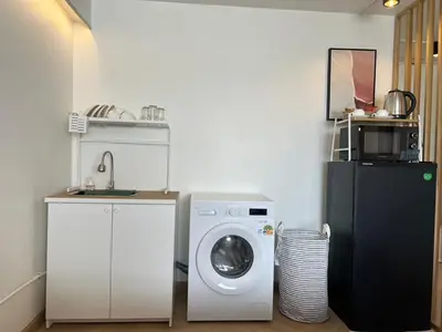 a kitchen with a washing machine and a refrigerator at Lazy House at Impact Muangthong in Thung Si Kan
