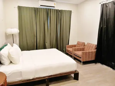 a bedroom with a bed and a couch and a chair at HD China Town MRT Dragon Temple กลางเยาวราช in Bangkok