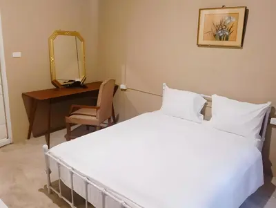 a bedroom with a bed and a desk and a mirror at xx Rest Inn Yaowarat เรสอินน์ เยาวราช in Samphanthawong