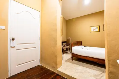 a door to a bedroom with a bed and a table at xx Rest Inn Yaowarat เรสอินน์ เยาวราช in Samphanthawong