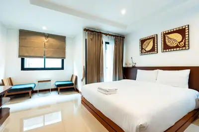 a hotel room with a bed and a table and chairs at XX YON INN Sukhumvit 4 Bangkok - BTS Nana in Bang Kapi