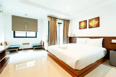 a hotel room with a white bed and a desk at XX YON INN Sukhumvit 4 Bangkok - BTS Nana in Bang Kapi
