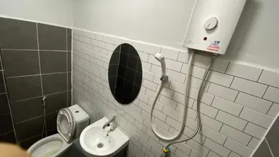 a bathroom with a toilet and a sink and a mirror at Capricorn hostel Yaowarat in Chinatown