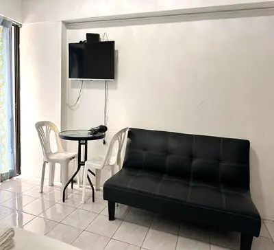 a living room with a black couch and a table at ATHIVAT Royal Pratunam in Bangkok
