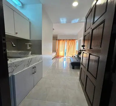a kitchen with a door open to a living room at ATHIVAT Royal Pratunam in Bangkok
