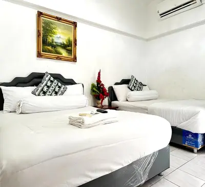 a room with two beds and a couch at ATHIVAT Royal Pratunam in Bangkok