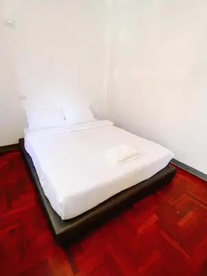 a white bed in a room with a wooden floor at XX GO INN Silom BTS Surasak สถานีสุรศักดิ์ in Yan Nawa