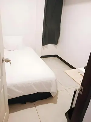 a bedroom with a white bed and a tiled floor at XX GO INN Asiatique Bangkok โก อินน์ เอเชียทีค เจริญกรุง in Bangkok