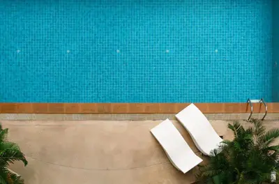 two white chairs sitting next to a swimming pool at Executive Suite 2 Beds Nana BTS 5 mins in Bangkok