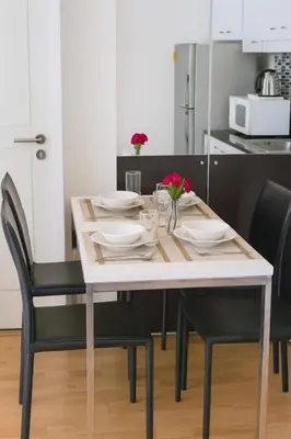 a dining room table with plates and flowers on it at Executive Suite 2 Beds Nana BTS 5 mins in Bangkok