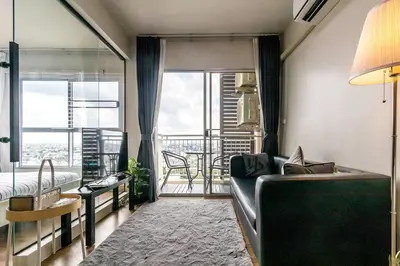 a living room with a couch and a balcony at TC Contel At True Digital Park in Amphoe Phra Khanong