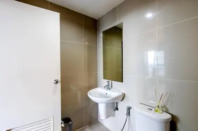 a white bathroom with a sink and a mirror at TC Contel At True Digital Park in Amphoe Phra Khanong