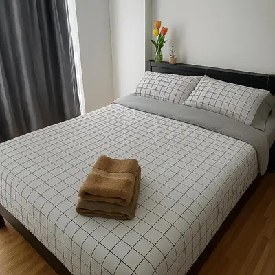 a bedroom with a bed with a towel on it at Laid back at IRIS Westgate Bangkok-Nonthaburi in Ban Bang Phai