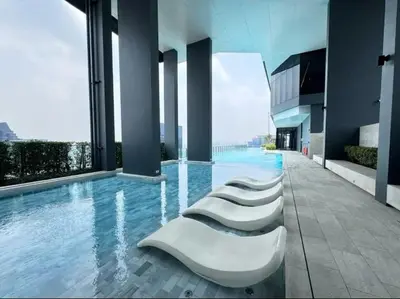 a row of white chairs in a swimming pool at City Lights Retreat in Bangkok