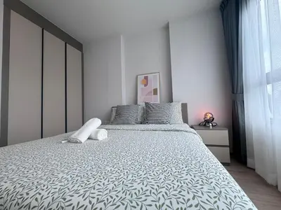 a bedroom with a large bed with white sheets at City Lights Retreat in Bangkok