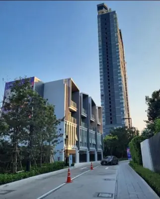 a street with a building and a car parked on the road at City Lights Retreat in Bangkok
