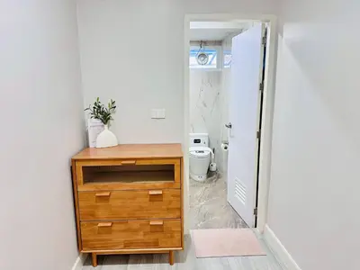 a bathroom with a wooden dresser and a toilet at Lovely Townhome in Shopping District near BTS&MRT in Bang Su