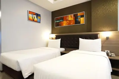 two beds in a hotel room with white sheets at Picnic Hotel Bangkok - Rang Nam in Bangkok