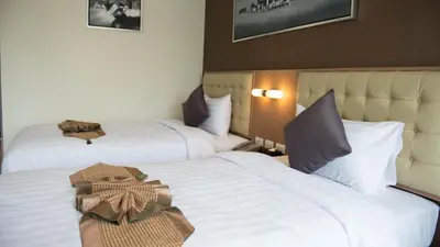 two beds in a hotel room with white sheets at Picnic Hotel Bangkok - Rang Nam in Bangkok