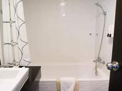 a white bathroom with a tub and a sink at Picnic Hotel Bangkok - Rang Nam in Bangkok