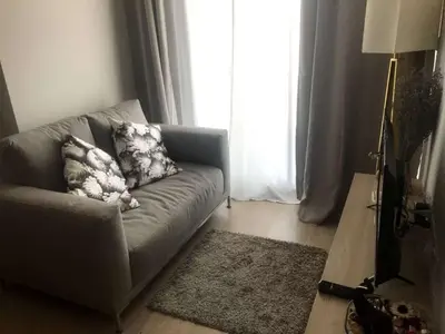 a living room with a couch and a window at Home hugs in Bangna