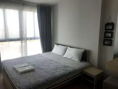 a bedroom with a bed with two towels on it at Home hugs in Bangna