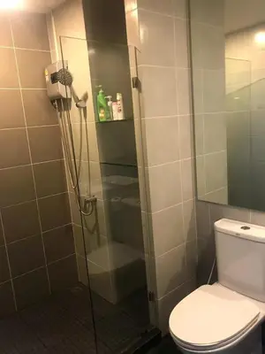 a bathroom with a glass shower with a toilet at Home hugs in Bangna