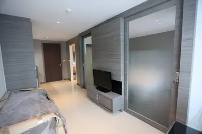 a bedroom with a tv and a large glass wall at Lummpni palace in Ban Bang Toei (1)