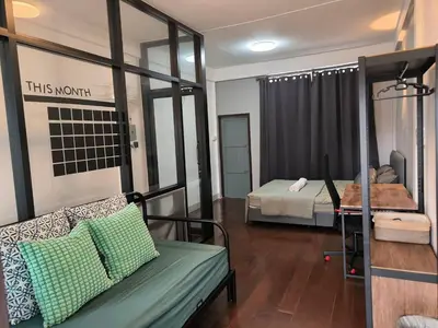 a room with a couch and a bed and a mirror at Charoen Nakhon 48 House in Godown