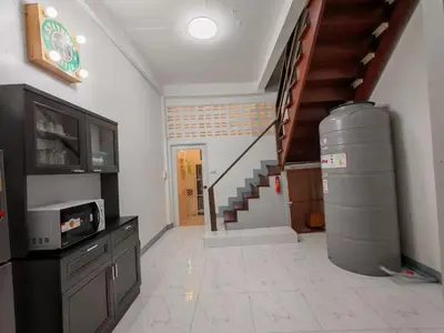 a living room with a staircase and a room with a tv at Charoen Nakhon 48 House in Godown