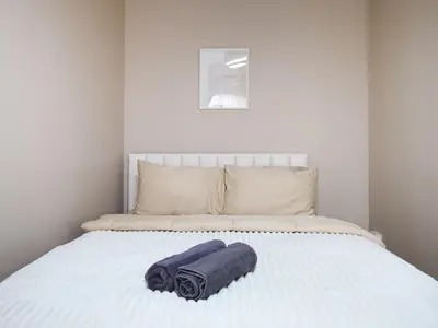 a bed with two towels laying on top of it at Cozy 2BR for 4 persons, Impact,Wi-Fi & Washer, DMK in Bangkok