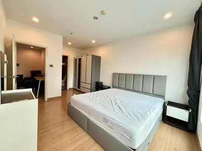 a bedroom with a large bed and a desk at Supalai Wellington 2 Near MRT in Bangkok