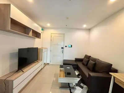 a living room with a couch and a flat screen tv at Supalai Wellington 2 Near MRT in Bangkok
