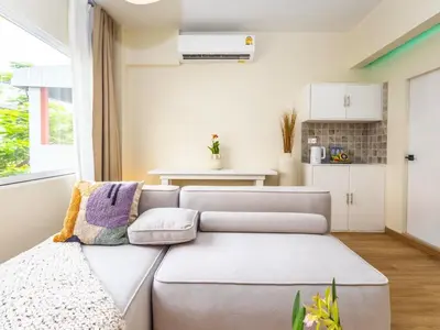 a living room with a couch and a kitchen at 2 Bedroom for 3 guests in heart Sathorn with Balcony in Bangkok