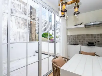 a kitchen with a white table and a large window at 2 Bedroom for 3 guests in heart Sathorn with Balcony in Bangkok