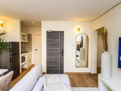 a living room with a white couch and a sliding door at 2 Bedroom for 4 guests Private in center of Sathorn in Bangkok