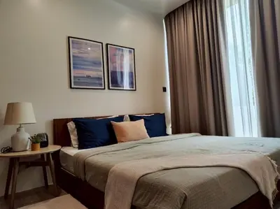 a bedroom with a large bed with blue pillows at Chobjai Hostelry - Chaw Cher Home at Bang Kra Jao in Bang Krasop