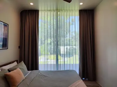 a bedroom with a bed and a large window at Chobjai Hostelry - Chaw Cher Home at Bang Kra Jao in Bang Krasop