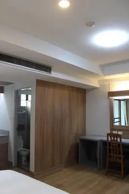 a room with a bed and a desk and a toilet at Bangkok Place Apartment - EKAMAI BTS in Bangkok