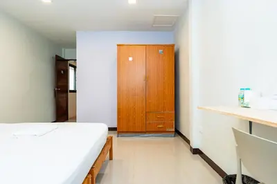 a bedroom with a bed and a wooden cabinet at xxThe Hidden Giant Swing เดอะ ฮิดเด้น เสาชิงช้า in Bangkok