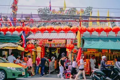 a group of people walking around a market with red lanterns at xxThe Hidden Giant Swing เดอะ ฮิดเด้น เสาชิงช้า in Bangkok