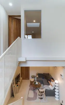 a person sitting on a couch in a living room at LumiLoft in Bangkok