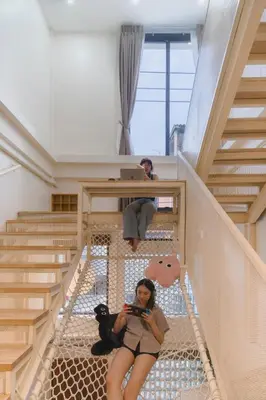 a woman sitting on the floor in a stair case at LumiLoft in Bangkok
