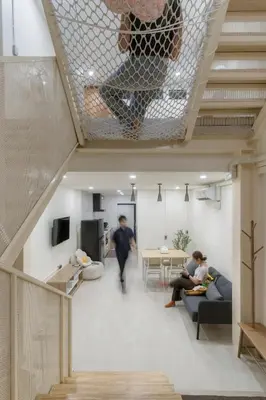 a living room with people sitting on couches and a table at LumiLoft in Bangkok