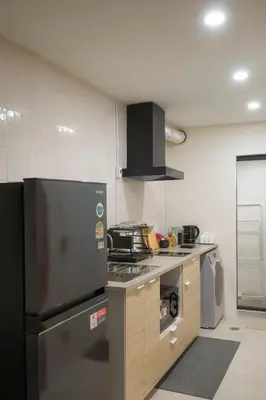 a kitchen with a stainless steel refrigerator and a stove at LumiLoft in Bangkok