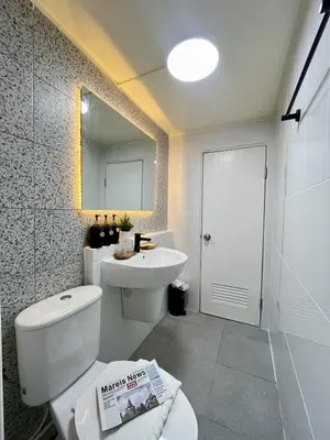 a bathroom with a toilet and a sink and a mirror at Happy House T8 in Thung Si Kan