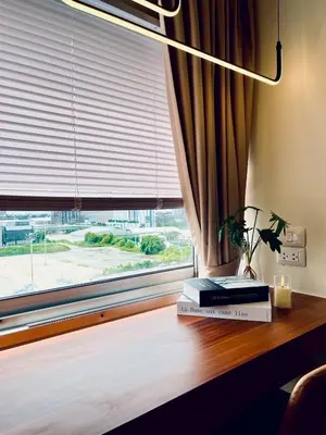 a table with books and a window with a lamp at Happy House T8 in Thung Si Kan