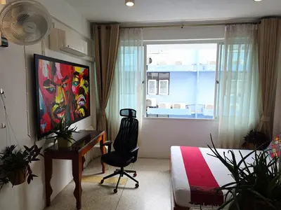 a bedroom with a desk and a bed and a window at Lumphini 3 Teakwood red at Steamy Location in Bangkok