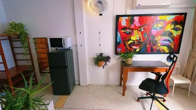 a room with a painting on the wall and a desk at Lumphini 3 Teakwood red at Steamy Location in Bangkok