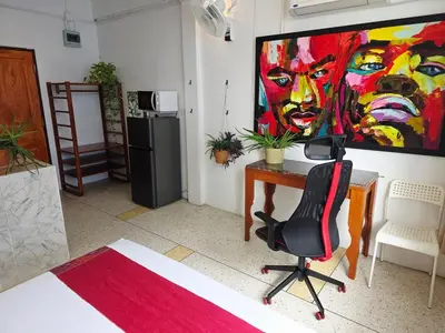 a room with a desk and a painting on the wall at Lumphini 3 Teakwood red at Steamy Location in Bangkok